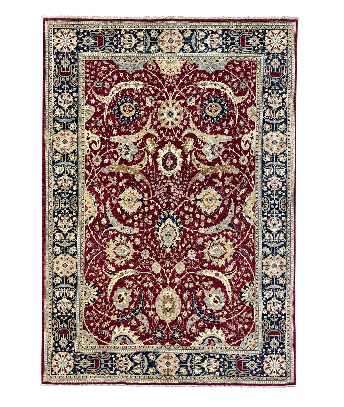 A traditional oriental-style area rug with an intricate floral and vine pattern, featuring a deep red central field, navy blue borders, and cream accents.