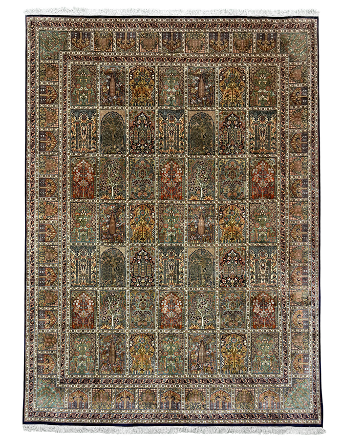 A rectangular traditional area rug with an intricate geometric and floral pattern, featuring a central field of arch motifs in muted earth tones and a decorative border, finished with white fringe on the top and bottom.
